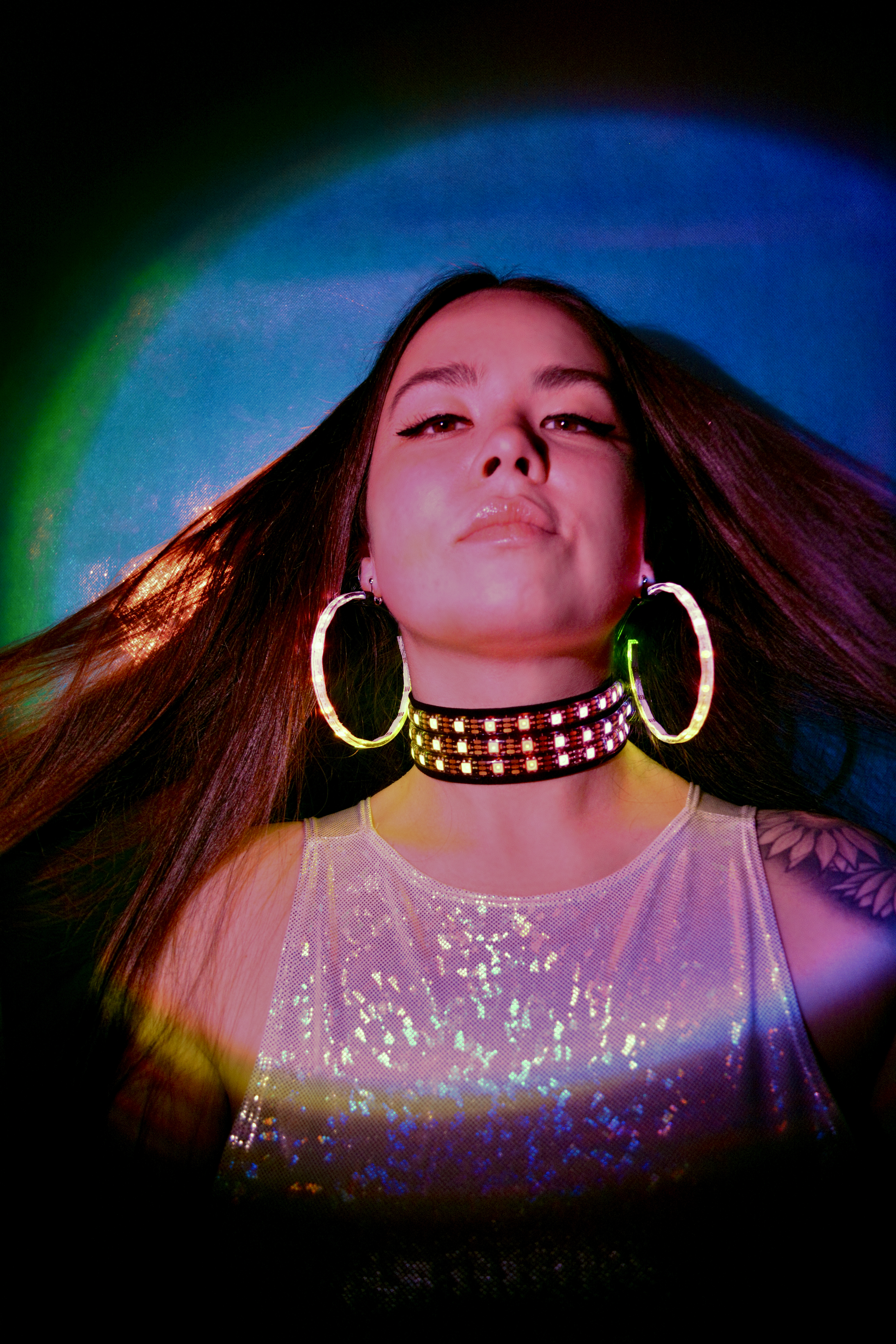 model with long brown hair wearing the led earrings & choker w/ a blue background